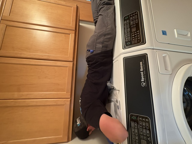 Aaron's Plumbing technician servicing a washer and dryer hookup