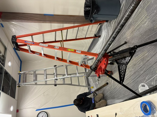 Technician threading steel pipe for a commercial plumbing project